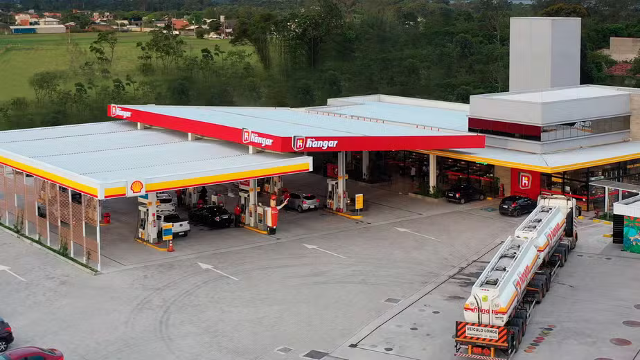 Vista aérea de um posto de combustíveis com caminhão-tanque estacionado, ilustrando a operação que gera custos e define a margem de lucro na nota fiscal.