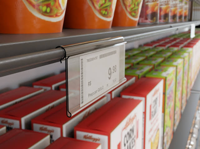 Prateleira de supermercado com produtos e etiqueta de preço em foco, ilustrando a confusão de valores gerada pela reforma tributária.