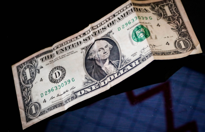 Nota de um dólar amassada sobre fundo escuro, ilustrando a flutuação cambial e o impacto no caixa empresarial.