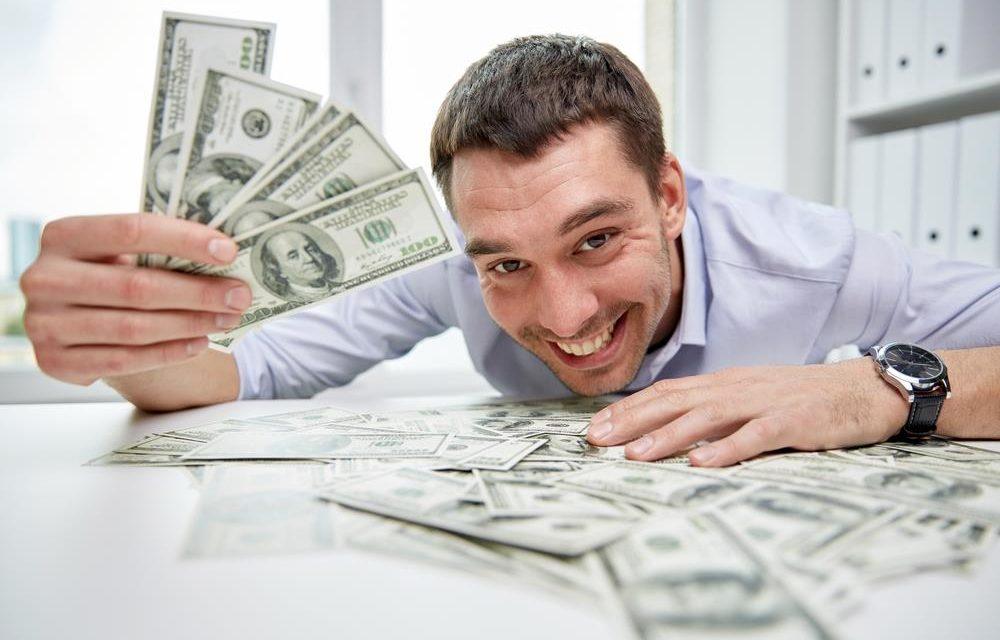 Homem sorridente deitado sobre uma mesa com notas de dinheiro espalhadas, ilustrando os desafios e o peso real de faturar alto no varejo brasileiro.