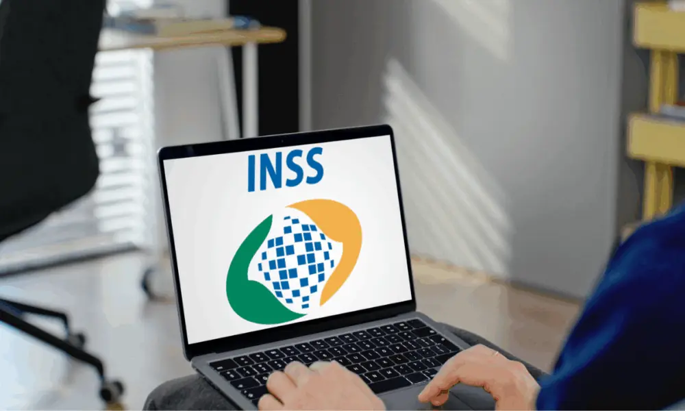 Notebook aberto exibindo o logotipo do INSS na tela, ilustrando o funcionamento do INSS Empresa.