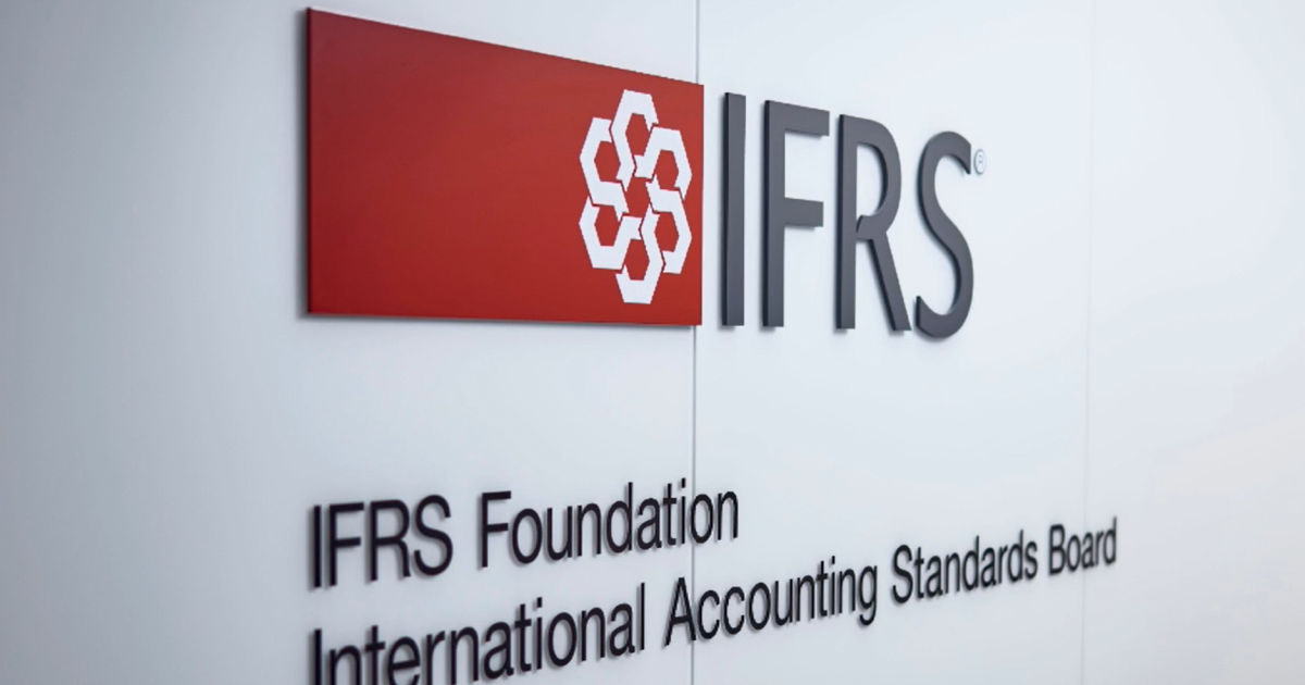 Logotipo em relevo da IFRS Foundation na parede branca, ilustrando a necessidade de as empresas se prepararem para as novas normas IFRS.