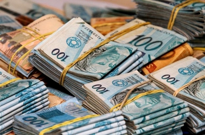 Maços de dinheiro em espécie com notas de cem reais, ilustrando investigações sobre a Máfia do ICMS.