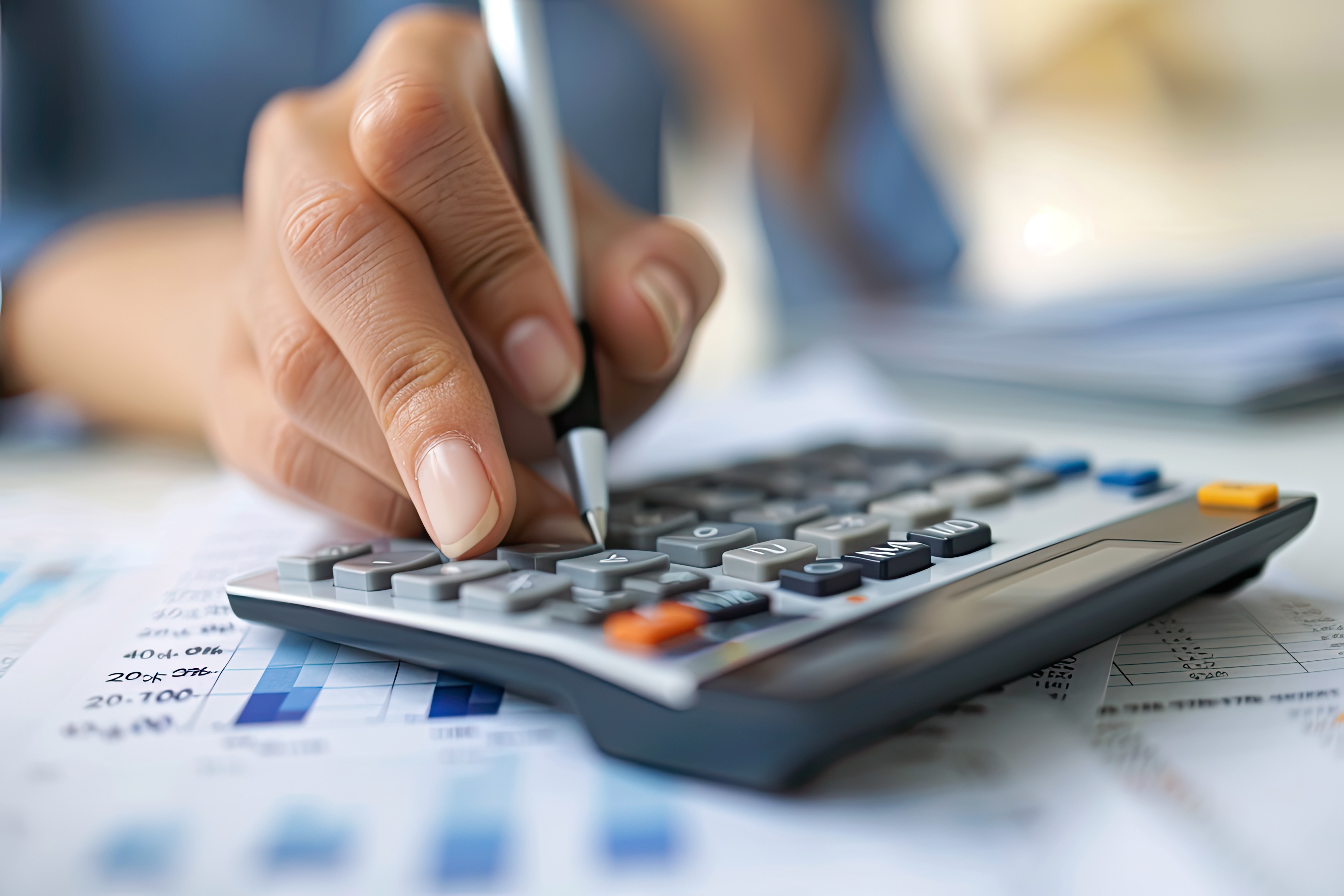 Pessoa usa caneta e calculadora para recalcular os custos das compras internacionais após o fim da taxa das blusinhas.
