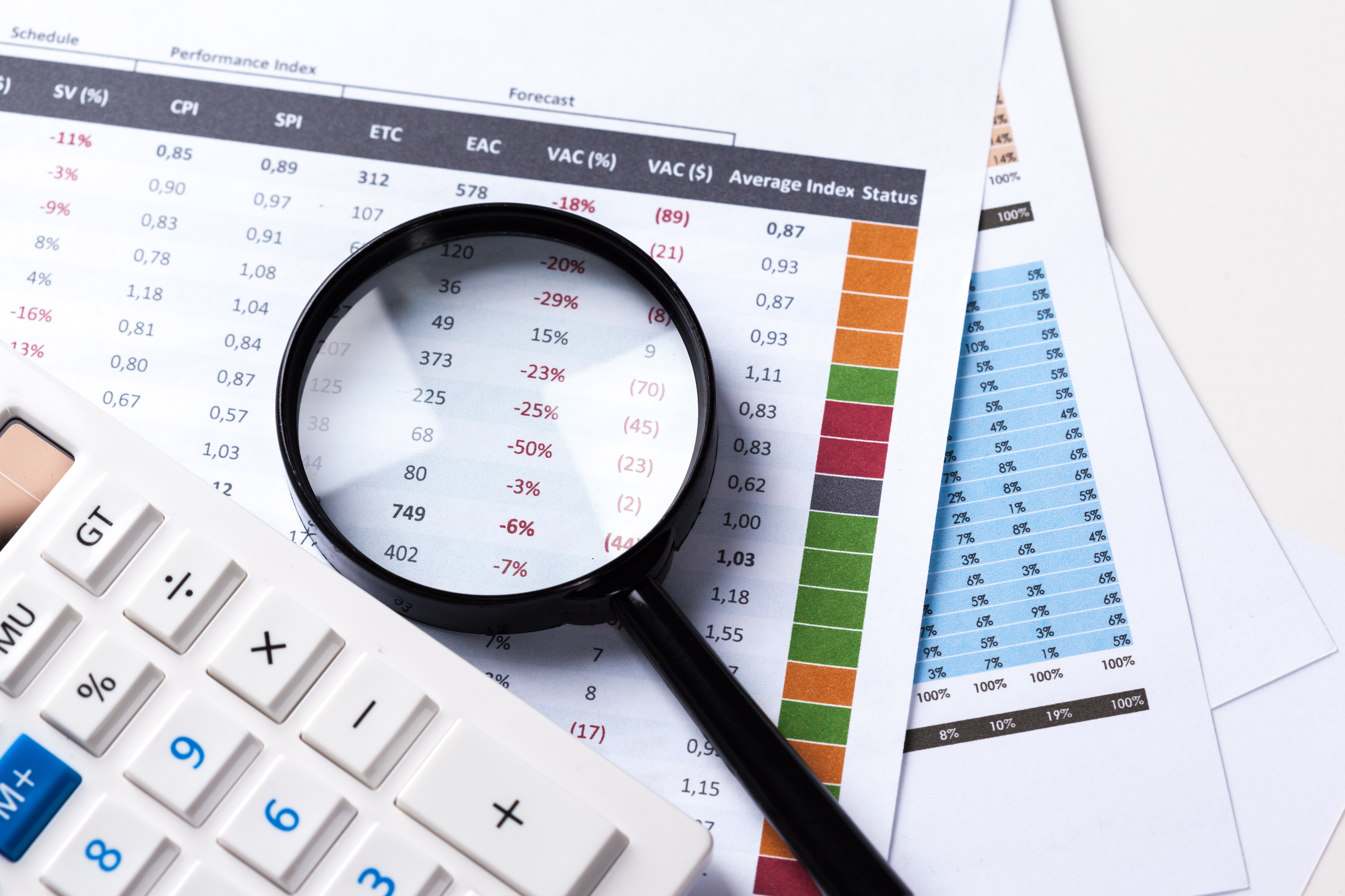 Lupa sobre planilhas financeiras e calculadora, ilustrando a gestão financeira rigorosa necessária em tempos de recuperação judicial.
